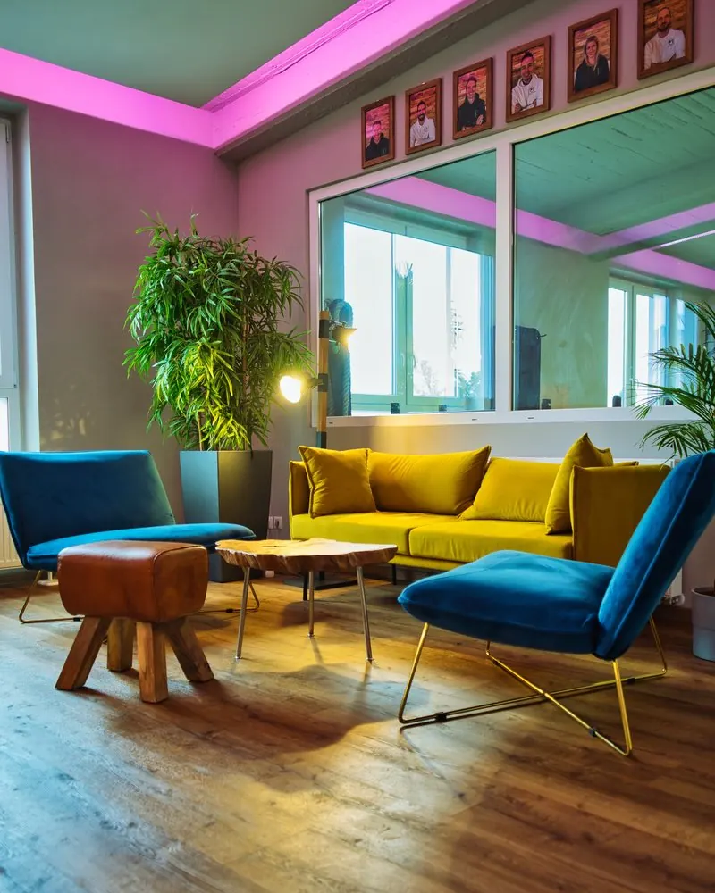 Lounge mit gelbem Sofa und blauen Sesseln in den Geschäftsräumen eines Unternehmens