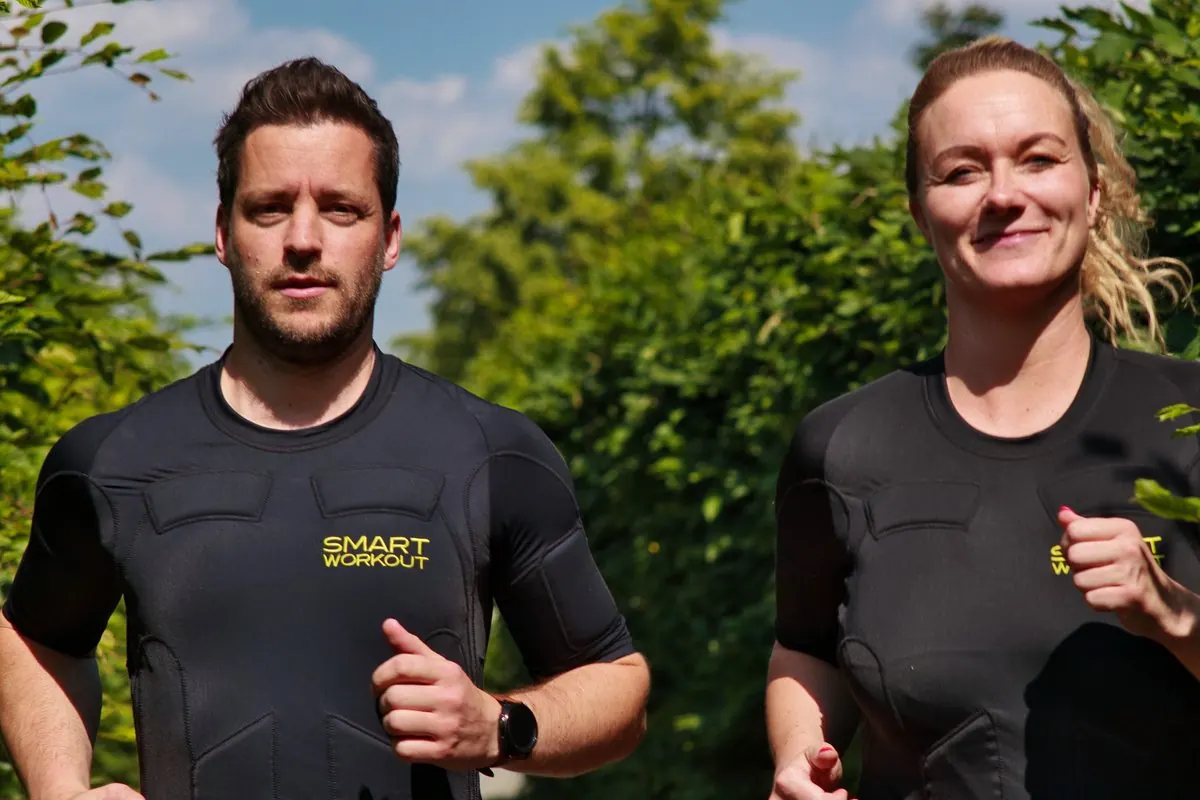 Werbefoto: ein Mann und eine Frau joggen in Funktionskleidung durch einen Park